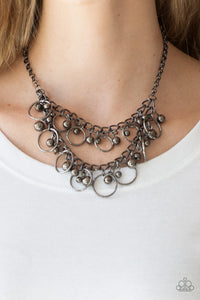 Item #P2IN-BKXX-148XX Brushed in a high-sheen finish, mismatched gunmetal beads and airy gunmetal hoops swing from two rows of gunmetal chains, creating an edgy fringe below the collar. Features an adjustable clasp closure.  Sold as one individual necklace. Includes one pair of matching earrings.