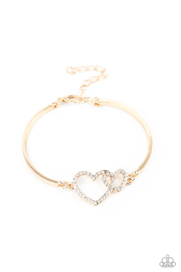 Cupid is Calling - Gold - Paparazzi Accessories -  Encrusted in dainty white rhinestones, a charming pair of interlocking heart frames attach to two gold bars around the wrist, creating a flirty bangle-like bracelet. Features an adjustable clasp closure.  Sold as one individual bracelet.