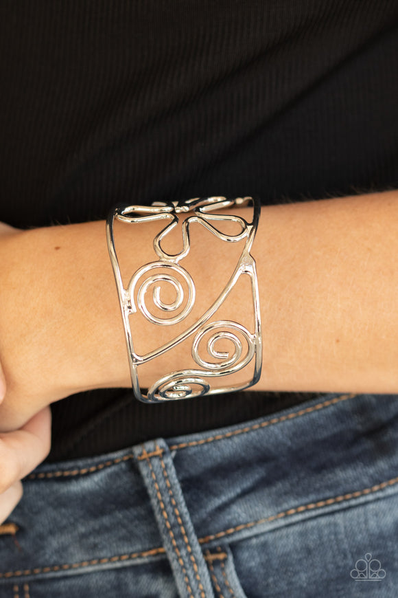 Groovy Sensations - Silver - Paparazzi Accessories -  Item #P9WH-SVXX-188XX Shiny silver wire bends and curls into groovy floral and swirl frames, coalescing into a psychedelic cuff around the wrist.  Sold as one individual bracelet.