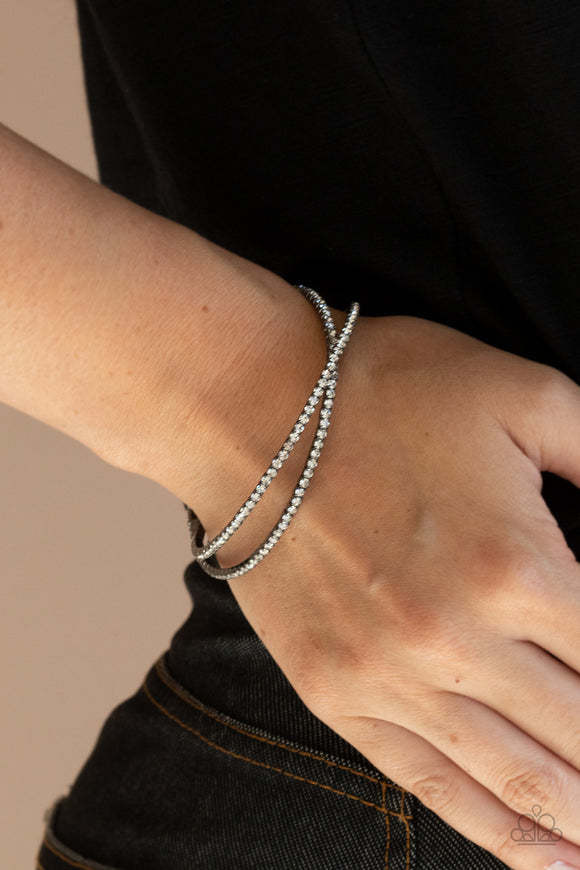 Plus One Status - Black - Paparazzi Accessories -  Item #P9RE-BKXX-307XX Radiant rows of glassy white rhinestones delicately intertwine into an airy gunmetal cuff around the wrist, creating a glamorous sparkle.  Sold as one individual bracelet.