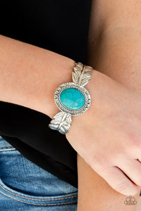 Western Wings - Blue - Paparazzi Accessories - Item #P9SE-BLXX-338XX Stamped and embossed in lifelike textures, two shiny silver feathers branch out from a turquoise stone frame featuring rustic silver details. The whimsical centerpiece curls around the wrist, creating a free-spirited cuff.  Sold as one individual bracelet.