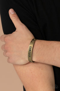 Item #P9MN-URBR-016XX Brass chain-like bars attach to a rustic brass centerpiece stamped in the powerful word, "CONQUER," creating a statement-making cuff around the wrist.  Sold as one individual bracelet.