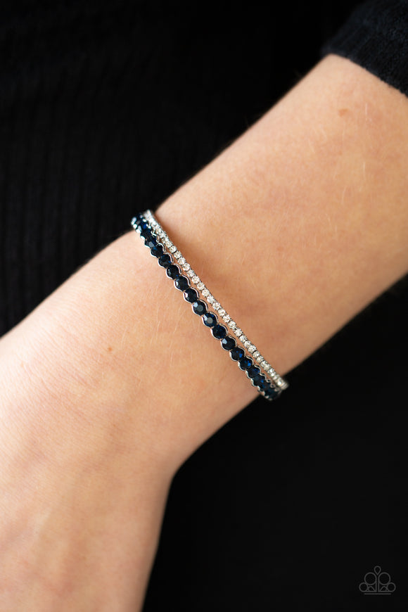 Fairytale Sparkle - Blue - Paparazzi Accessories -  Item #P9RE-BLXX-185XX Mismatched strands of glassy white and glittery blue rhinestones stack into a dainty cuff around the wrist, creating a sparkly centerpiece.  Sold as one individual bracelet.