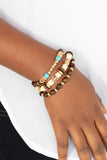 Belongs In The Wild - Gold - Paparazzi Accessories -  Item #P9SE-GDXX-037XX A mismatched collection of brown wooden beads, gold accents, turquoise stones, and glassy beads are threaded along stretchy bands, creating colorful layers around the wrist.  Sold as one set of three bracelets.