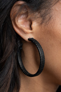 Leather-Clad Legend - Black - Paparazzi Accessories -  Item #P5HO-BKXX-205XX A black leather lace wraps around a thick silver hoop, creating an edgy display. Earring attaches to a standard post fitting. Hoop measures approximately 2 1/2" in diameter.  Sold as one pair of hoop earrings.