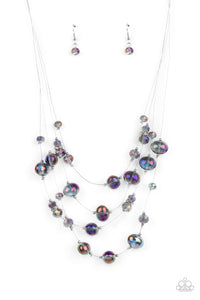 Cosmic Real Estate - Multi - Paparazzi Accessories -  Item #P2SE-MTXX-208XX Featuring an oil spill finish, glassy beads and faceted crystal-like accents are fitted in place along dainty wires, creating the illusion of floating layers below the collar. Dainty silver beads and white rhinestone encrusted silver rings sporadically embellish the stellar display for a timeless finish. Features an adjustable clasp closure.  Sold as one individual necklace. Includes one pair of matching earrings.