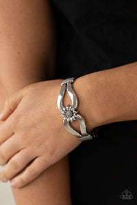 Let A Hundred SUNFLOWERS Bloom - Silver - Paparazzi Accessories -  Item #P9WH-SVXX-217XX Antiqued silver ribbons loop out from a decorative silver sunflower that attaches to a ribbed silver frame, creating a cuff-like bangle around the wrist. Features a hinged closure.  Sold as one individual bracelet.