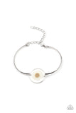 Cottage Season - White - Paparazzi Accessories -  Item #P9WH-WTXX-216XX Encased in a glassy fitting, a whimsical white daisy centerpiece attaches to two arcing silver bars around the wrist for an enchanting floral look. Features an adjustable clasp closure.  Sold as one individual bracelet.