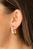 Ready, Steady, GLOW - Gold - Paparazzi Accessories -   Item #P5CO-GDXX-051XX Featuring emerald style cuts, a row of glassy white rhinestones adorn the top front of a thick gold hoop for a classic finish. Earring attaches to a standard clip-on fitting.  Sold as one pair of clip-on earrings.