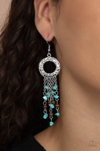 Primal Prestige - Blue - Paparazzi Accessories -  Item #P5SE-BLXX-262XX Tapered tassels of dainty wooden beads and turquoise pebbles stream from the bottom of a hammered silver hoop, creating an earthy fringe. Earring attaches to a standard fishhook fitting.  Sold as one pair of earrings.