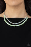 Parisian Princess - Green - Paparazzi Accessories -  Item #P2RE-GRXX-231XX A strand of glassy white crystal-like beads and pearly Green Ash beads and white rhinestone encrusted silver rings layer below the collar, creating a timeless display. Features an adjustable clasp closure.  Sold as one individual necklace. Includes one pair of matching earrings.