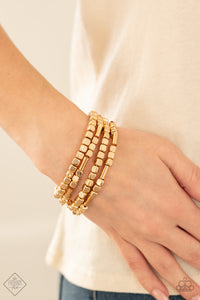 Metro Materials - Gold - Paparazzi Accessories -  Item #P9BA-GDXX-085ZX Lightweight and flirty, two strands of golden square beads interspersed with gold cylinders, are paired with two strands of gold cubes. The four stretchy bracelets come together to create an irresistible stack of metallic mayhem.  Sold as one individual bracelet.  2021 APRIL FASHION FIX