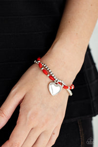 Candy Gram - Red  - Paparazzi Accessories -  Item #P9WH-RDXX-159XX A shiny silver heart dangles from a strand of fiery red beads. It is paired with a strand of round silver beads threaded along a stretchy band for a whimsical display around the wrist.  Sold as one pair of bracelets.