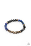 Petrified Powerhouse - Blue - Paparazzi Accessories -  Item #P9UR-BLXX-180XX A collection of smooth round Lapiz and polished stones, punctuated by faceted antiqued brass beads, are threaded along a stretchy band and wrap around the wrist for an elementally earthy effect.  Sold as one individual bracelet.