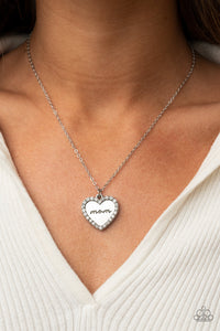 The Real Boss - White - Paparazzi Accessories -  Item #P2WD-WTXX-187XX Infused with a glassy white rhinestone encrusted silver heart, a silver heart shaped pendant is stamped in the word, "Mom," as it swings below the collar, creating a sparkly sentimental statement piece. Features an adjustable clasp closure.  Sold as one individual necklace. Includes one pair of matching earrings.