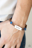 WISH This Way - Blue - Paparazzi Accessories -  Item #P9WD-URBL-187XX An oval silver plate engraved with the word "WISH" creates a warmhearted medallion as it connects to brown cording interwoven with wooden and glossy blue beads for a harmonious vibe around the wrist. Features an adjustable sliding knot closure.  Sold as one individual bracelet.