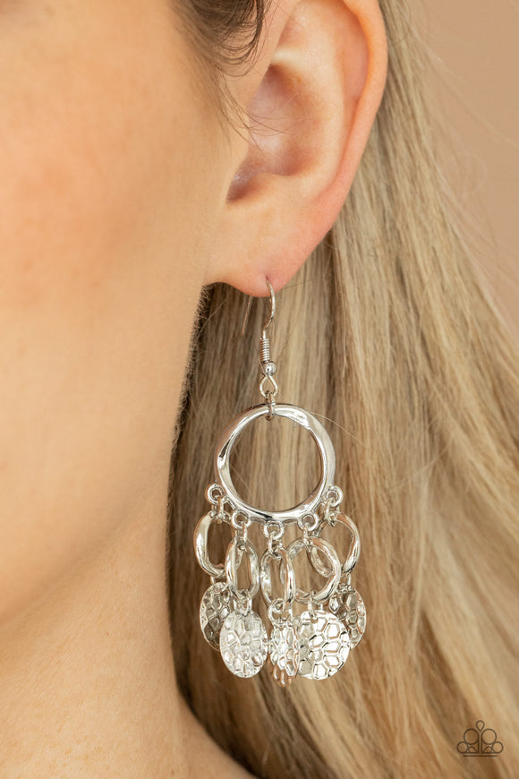 Partners in CHIME - Silver - Paparazzi Accessories -  Item #P5IN-SVXX-084XX Embossed in tactile geometric patterns, shiny silver discs swing from the bottom of dainty silver rings at the bottom of an asymmetrical silver ring for a noise-making fashion. Earring attaches to a standard fishhook fitting.  Sold as one pair of earrings.