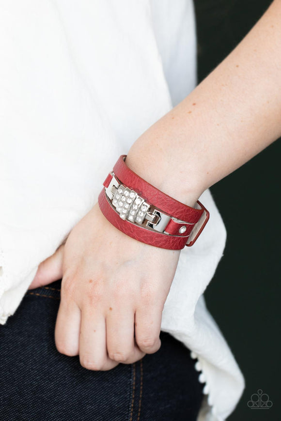 Ultra Urban - Red - Paparazzi Accessories -  Item #P9UR-RDXX-133XX A white rhinestone silver centerpiece is studded in place by white rhinestone encrusted silver studs across the spliced center of a red leather band, creating a glittery urban look around the wrist. Features an adjustable snap closure.  Sold as one individual bracelet.