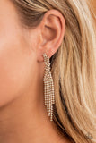 Cosmic Candescence - Gold - Paparazzi Accessories -  Item #P5PO-GDXX-195XX Encased in glistening gold fittings, dainty strands of glittery white rhinestones delicately overlap into a tapered tassel for a twinkly look. Earring attaches to a standard post fitting.  Sold as one pair of post earrings.