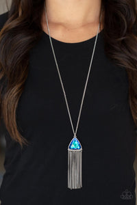 Item #P2RE-BLXX-334XX Featuring an iridescent UV shimmer, an oversized blue triangular gem swings from the bottom of a lengthened silver chain. A curtain of silver chains streams out from the bottom of the sparkly pendant, adding playful movement to the glamorous statement piece. Features an adjustable clasp closure.  Sold as one individual necklace. Includes one pair of matching earrings.