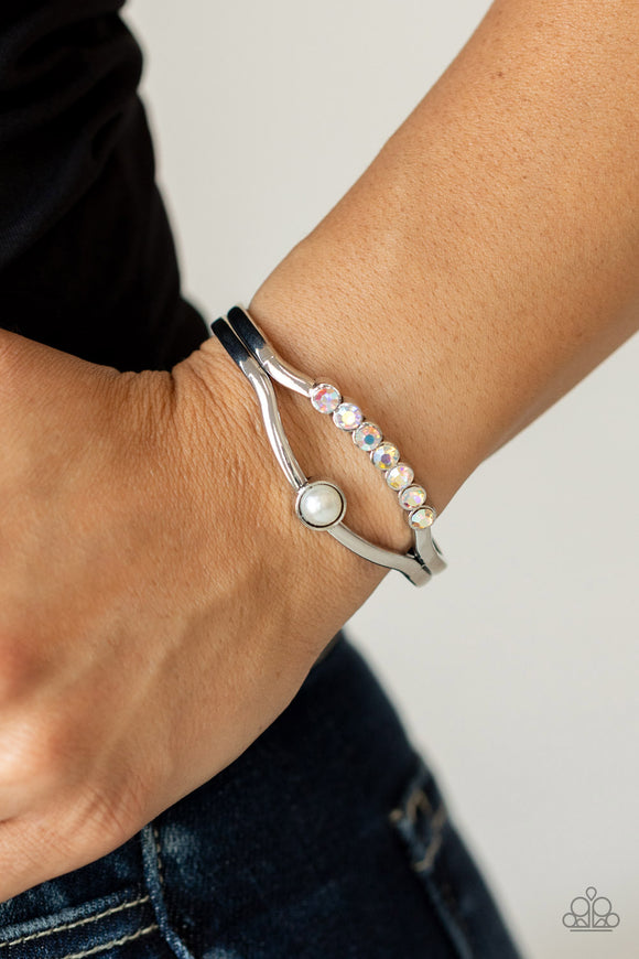 Palace Prize - Multi - Paparazzi Accessories -  Item #P9RE-MTXX-074XX A row of iridescent rhinestones and a solitaire white pearl adorn the layered center of a classic silver cuff, creating a timeless piece around the wrist.  Sold as one individual bracelet.