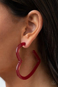 Heart-Throbbing Twinkle - Red - Paparazzi Accessories -  Item #P5HO-RDXX-026XX Dusted in sparkles, a red acrylic frame delicately curls into a flat heart frame for a flirtatious finish. Earring attaches to a standard post fitting. Hoop measures approximately 2 1/2" in diameter.  Sold as one pair of hoop earrings.