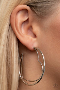 Love Goes Around - Silver - Paparazzi Accessories -  Item #P5HO-SVXX-305XX A silver wire heart is encircled in an oversized silver hoop, resulting in a heart-stopping shimmer. Earring attaches to a standard post fitting. Hoop measures approximately 2" in diameter.  Sold as one pair of hoop earrings.