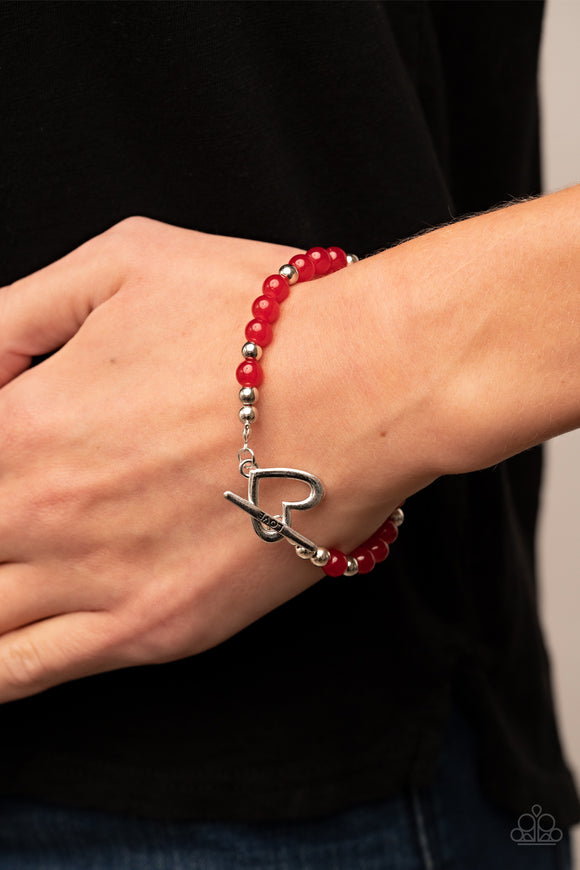 Following My Heart - Red - Paparazzi Accessories -  Item #P9WH-RDXX-172XX A shiny silver heart frame interlocks with a toggle closure at the center of a shiny silver and glassy red beaded bracelet. The silver toggle is stamped in the word, 