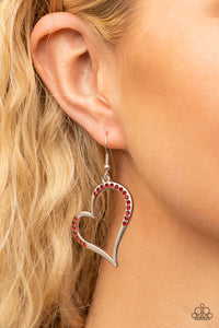 Tenderhearted Twinkle - Red - Paparazzi Accessories -  Item #P5WH-RDXX-157XX A curvaceous silver heart is encrusted in sections of fiery red rhinestones, invoking a flirtatious flair. Earring attaches to a standard fishhook fitting.  Sold as one pair of earrings.