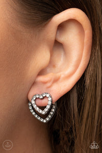 Ever Enamored - Black - Paparazzi Accessories -  Item #P5PO-BKXX-203XX A dainty gunmetal heart dotted in glassy white rhinestones flirtatiously attaches to a double-sided post, while a slightly larger white rhinestone encrusted gunmetal heart peeks out beneath the ear for a romantic finish. Earring attaches to a standard post fitting.  Sold as one pair of double-sided post earrings.