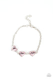 Item #P9WH-PKXX-297XX Nestled in silver frames, a trio of glittery pink heart-shaped gems delicately links across the wrist for a dash of swoon-worthy shimmer. Features an adjustable clasp closure.  Sold as one individual bracelet.