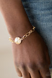 All Aglitter - Gold - Paparazzi Accessories  A dramatic golden gem attaches to a shiny gold chain, creating a blinding centerpiece atop the wrist. Features a toggle closure.  Sold as one individual bracelet.   Get The Complete Look! Necklace: "She Sparkles On - Gold" (Sold Separately) SN0198