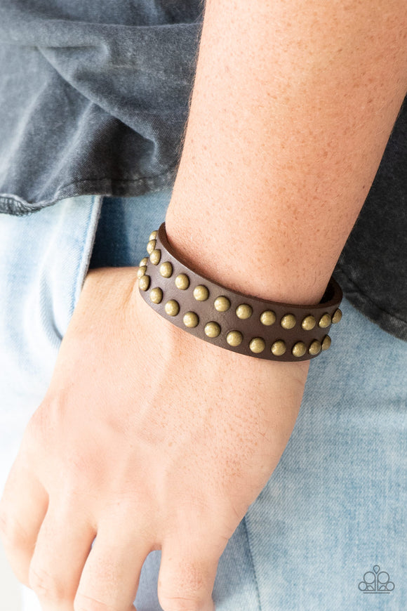 Biker Bold - Brown - Paparazzi Accessories  Rows of burnished brass studs are encrusted along the front of a brown leather band for a rugged look. Features an adjustable snap closure.  Sold as one individual bracelet.  P9UR-BNXX-391XX