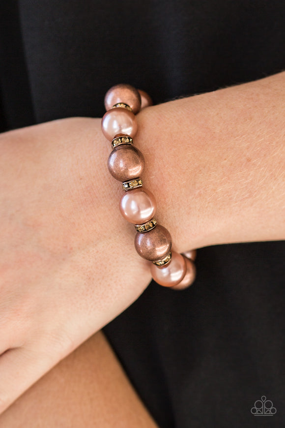 So Not Sorry - Copper/Brown - Paparazzi Accessories  A collection of topaz rhinestone encrusted rings, pearly copper beads, and classic copper beads are threaded along a stretchy band around the wrist for a glamorous look.  Sold as one individual bracelet.