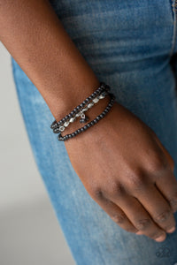 Tour de Tranquility - Black - Paparazzi Accessories  A collection of black stone beads and faceted silver beads are threaded along stretchy bands around the wrist, creating earthy layers.  Sold as one set of three bracelets.