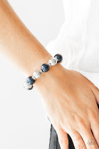 So Not Sorry - Blue - Paparazzi Accessories  A collection of white rhinestone encrusted rings, blue pearls, and classic silver beads are threaded along a stretchy band around the wrist for a glamorous look.  Sold as one individual bracelet.