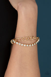 Glamour Grid - Gold - Paparazzi Accessories  Infused with oversized gold fittings, a strand of glittery white rhinestones and exaggerated gold chain connect to a classic gold chain that has been threaded along a stretchy band for a versatile fit.  Sold as one individual bracelet.