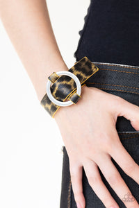 PAPARAZZI ACCESSORIES - Jungle Cat Couture - Yellow Featuring a shiny yellow cheetah pattern, a textured piece of leather loops through the center of a shimmery silver hoop for a sassy urban look. Features an adjustable belt loop closure.  Sold as one individual bracelet.