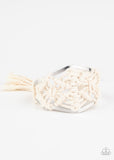 Macrame Mode - White White cording decoratively knots and weaves around an airy silver cuff for a macramé inspired look. Knotted around the ends, white tassels flair out from bottoms of the cuff for a wanderlust finish.  Sold as one individual.