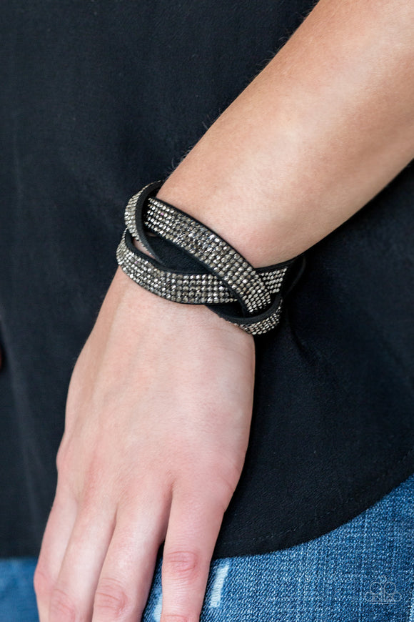 Nice Girls Finish Last - Black - Paparazzi Accessories - Item #P9DI-URBK-155XX Encrusted in row after row of glittery hematite rhinestones, three black suede bands braid across the wrist for a sassy look. Features an adjustable snap closure.  Sold as one individual bracelet.