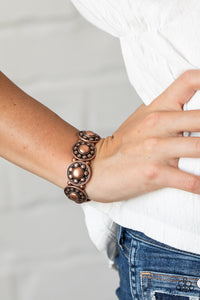 Rural Fields - Copper - Paparazzi Accessories - Item #P9BA-CPXX-036XX Studded and dotted in decorative floral patterns, antiqued copper frames are threaded along stretchy bands around the wrist for a seasonal flair.  Sold as one individual bracelet.