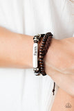 Let Faith Be Your Guide - Brown - Paparazzi Accessories - Item #P9UR-BNXX-504XX A strand of wooden beads and a braided band of brown suede flank a piece of beaded leather that features the silver frame stamped in the word, "faith," creating earthy layers around the wrist. Features an adjustable sliding knot closure.  Sold as one individual bracelet.