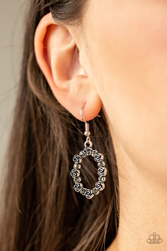 Rosy Royal - Silver/Smokey - Paparazzi Accessories -  #P5DA-SVXX-069XX  Dainty smoky rhinestones alternate with silver rosebud frames, coalescing into a whimsical floral frame. Earring attaches to a standard fishhook fitting.  Sold as one pair of earrings at DeesBlings.com - Affordable Fashion Jewelry that is Lead and Nickel free.