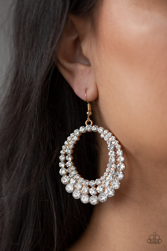 Universal Shimmer - Gold - Paparazzi Accessories -  P5RE-GDXX-184XX  Rings of glittery white rhinestones collect into a blinding frame in a dramatically glamorous fashion. Earring attaches to a standard fishhook fitting.  Sold as one pair of earrings by DeesBlings.com - Affordable Fashion Jewelry that is Lead and Nickel free.
