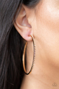 Trending Twinkle - Gold - Paparazzi Accessories  The front half of a gold hoop is encrusted in peach rhinestones for a radiant look. Earring attaches to a standard post fitting. Hoop measures 2 1/4" in diameter.  Sold as one pair of hoop earrings.