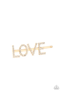 All You Need Is Love - Gold - Paparazzi Accessories Item #P7SS-GDXX-030XX  Encrusted in glassy white rhinestones, glistening gold letters spell out the word, "LOVE," across the front of a gold bobby pin for a lovable look.  Sold as one individual hair clip.