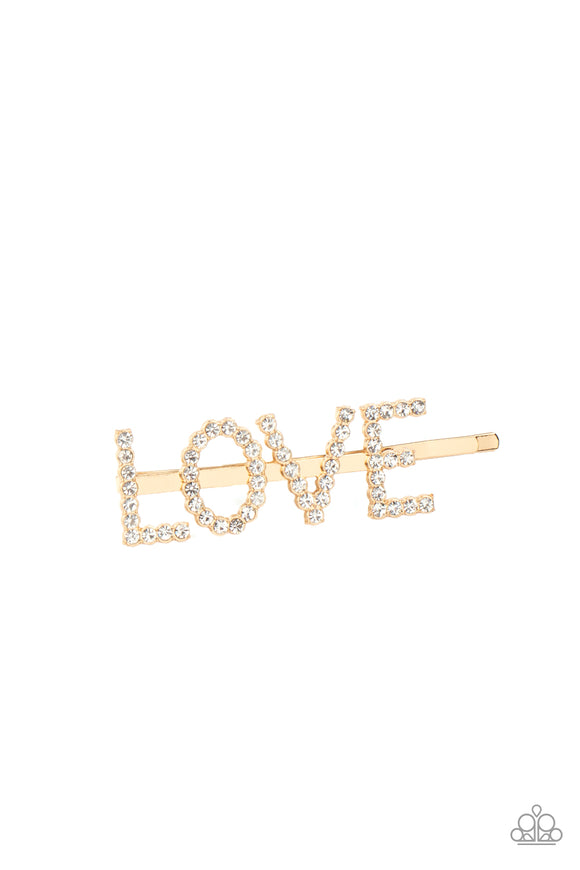 All You Need Is Love - Gold - Paparazzi Accessories Item #P7SS-GDXX-030XX  Encrusted in glassy white rhinestones, glistening gold letters spell out the word, 