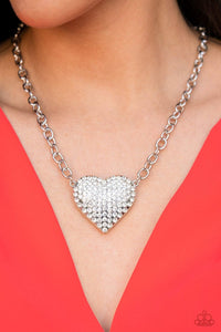 Heartbreakingly Blingy - White - Paparazzi Accessories -  A dramatically oversized silver heart frame is encrusted in row after row of dazzling white rhinestones, resulting in heart-racing sparkle below the collar. Features an adjustable clasp closure.  Sold as one individual necklace. Includes one pair of matching earrings.  Life of the Party - Jan 2022