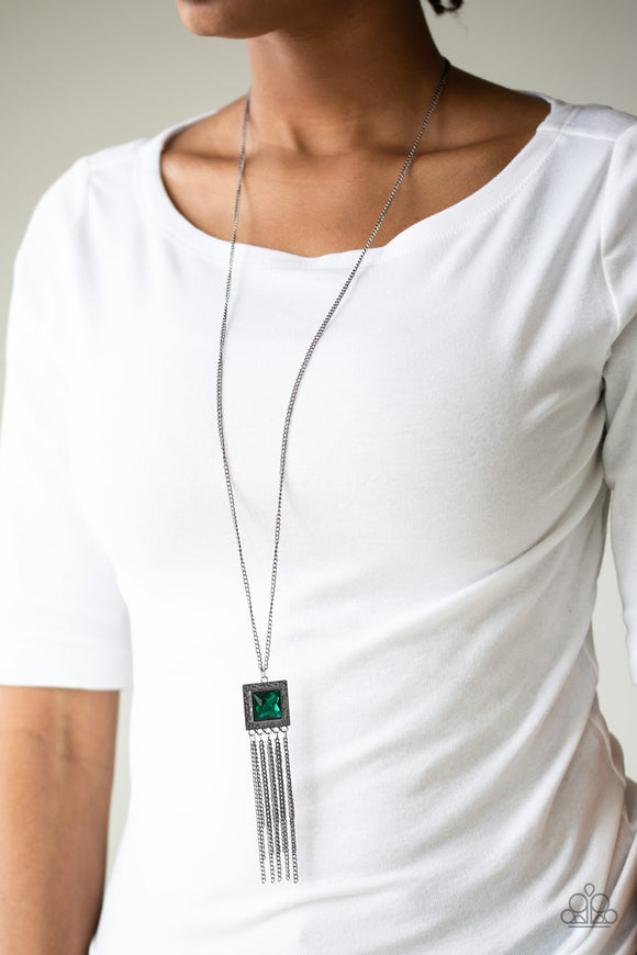 Shimmer Sensei - Green - Paparazzi Accessories -  P2ED-GRXX-038XX  Swinging from the bottom of a lengthened gunmetal chain, a delicately hammered square frame gives way to a shimmery gunmetal fringe. Featuring a regal square cut, a glittery green gem is pressed into the center of the pendant for an edgy look. Features an adjustable clasp closure.  Sold as one individual necklace. Includes one pair of matching earrings.