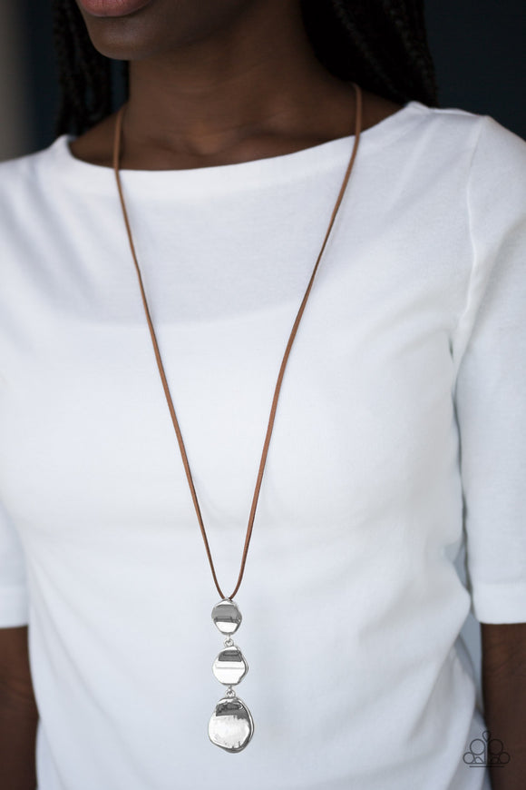 Embrace The Journey - Brown - Paparazzi Accessories  Delicately hammered in a glistening shimmer, asymmetrical silver frames link at the bottom of a lengthened brown suede strand for a bold artisanal look. Features an adjustable clasp closure.  Sold as one individual necklace. Includes one pair of matching earrings.